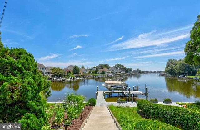 dock area featuring boat lift and a water view