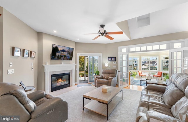 living area with a fireplace with flush hearth, recessed lighting, french doors, and a ceiling fan