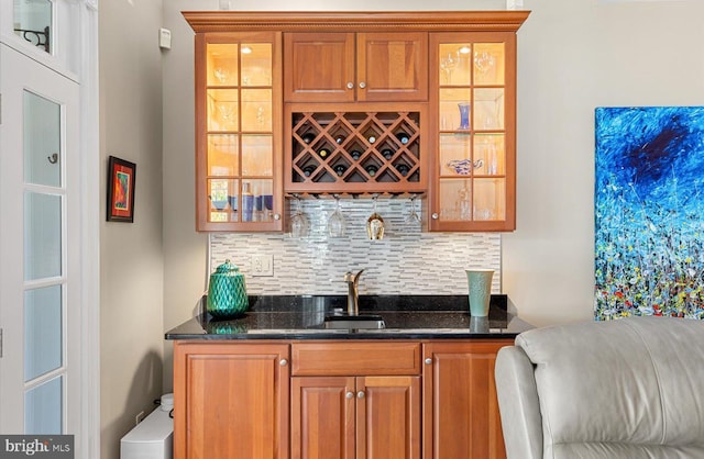 bar featuring a sink, indoor wet bar, and decorative backsplash