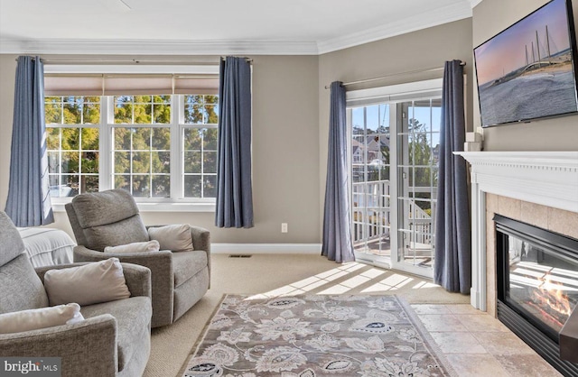 living area featuring baseboards, visible vents, a tile fireplace, ornamental molding, and light carpet