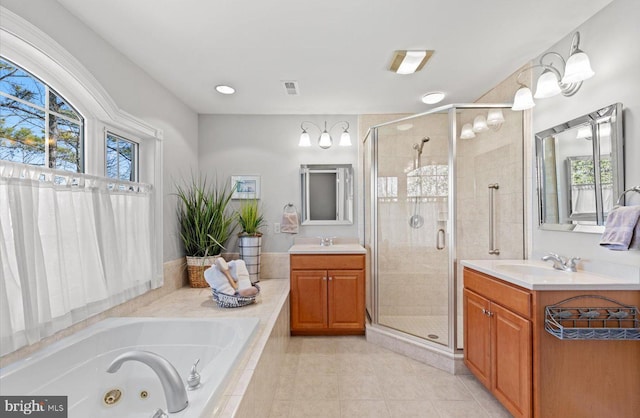 bathroom featuring tile patterned flooring, a shower stall, a jetted tub, and two vanities