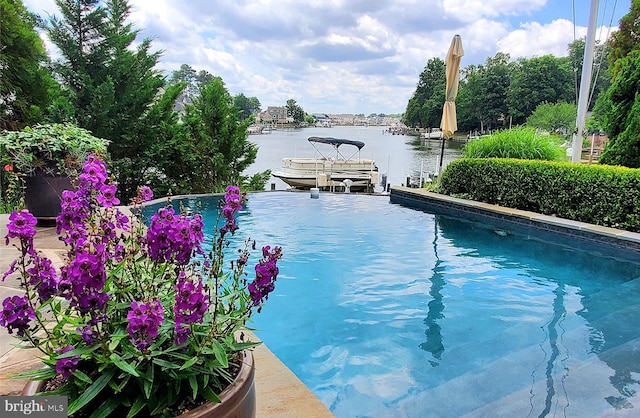 view of swimming pool with a boat dock and a water view