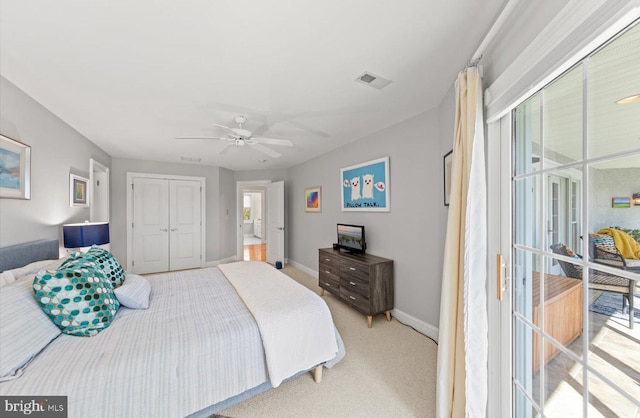 bedroom with visible vents, a closet, baseboards, light colored carpet, and ceiling fan