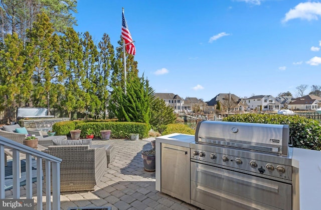 view of patio with grilling area, a residential view, and exterior kitchen