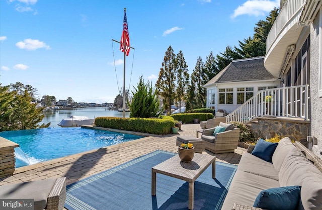 view of pool with a water view, an infinity pool, outdoor lounge area, a sunroom, and a patio area