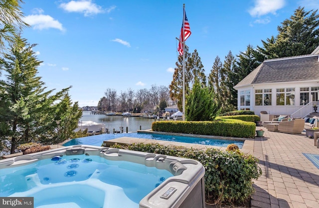 view of pool with a patio, an outdoor living space, a water view, and a hot tub