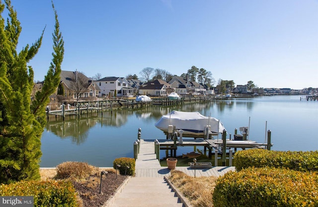 view of dock featuring a water view, a residential view, and boat lift