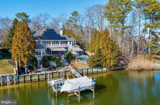 rear view of property with stairway, a pool, a chimney, boat lift, and a patio area