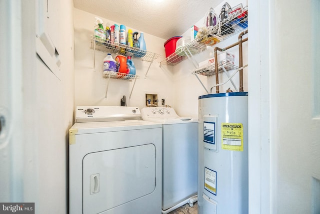 clothes washing area featuring washer and clothes dryer, laundry area, a textured ceiling, and electric water heater