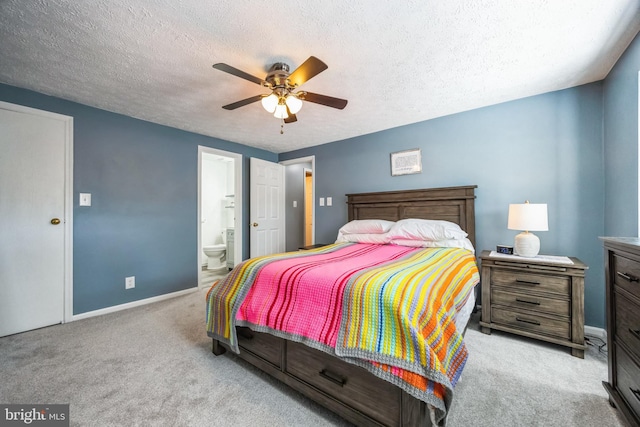 carpeted bedroom featuring ensuite bath, a textured ceiling, baseboards, and a ceiling fan