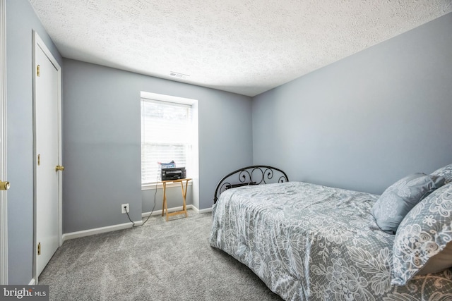 bedroom with carpet flooring, visible vents, baseboards, and a textured ceiling