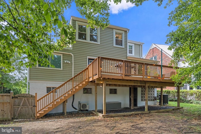 rear view of property with fence, stairs, a wooden deck, a gate, and ac unit