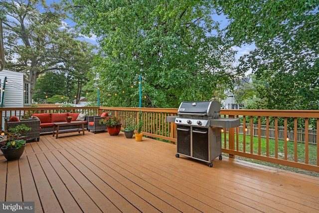 wooden deck with a grill, fence, and outdoor lounge area