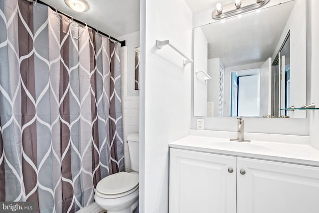 bathroom with vanity, curtained shower, and toilet