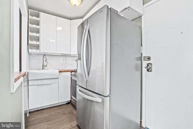 kitchen featuring a sink, tasteful backsplash, dark wood-style floors, appliances with stainless steel finishes, and white cabinets