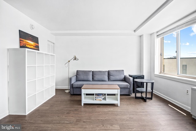 living area with baseboards and wood finished floors