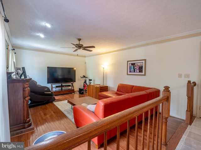 living area with ornamental molding, a ceiling fan, and wood finished floors