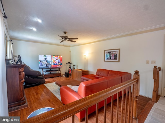 living room featuring a ceiling fan, crown molding, and wood finished floors