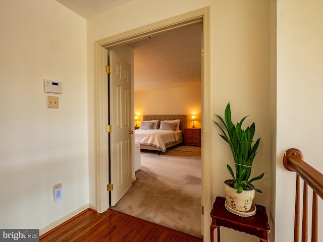 bedroom with carpet flooring, baseboards, and wood finished floors