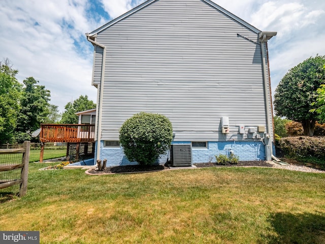 view of property exterior with cooling unit, a lawn, and a wooden deck