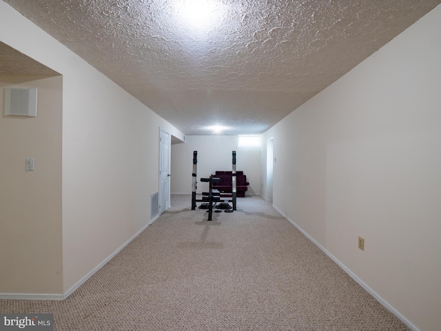 interior space with carpet floors, baseboards, visible vents, and a textured ceiling