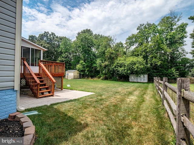 view of yard with a patio, a sunroom, fence, a storage unit, and an outdoor structure