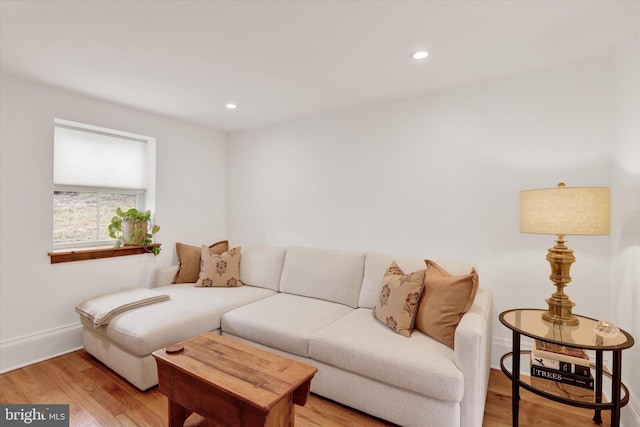 living room featuring recessed lighting, baseboards, and light wood finished floors