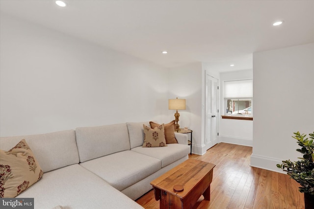 living area featuring recessed lighting, baseboards, and light wood finished floors