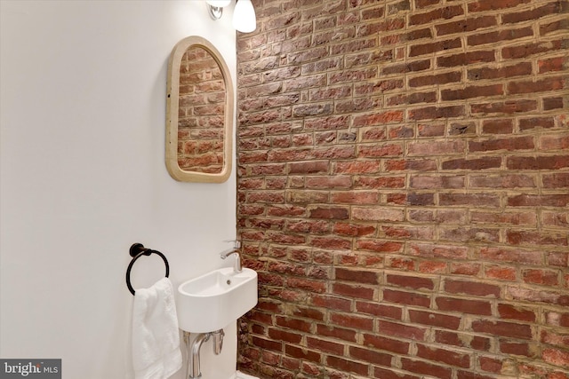 bathroom featuring brick wall