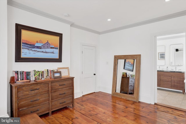 bedroom with crown molding, recessed lighting, wood-type flooring, ensuite bath, and baseboards