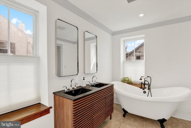 bathroom featuring a freestanding tub, tile patterned flooring, a sink, and crown molding