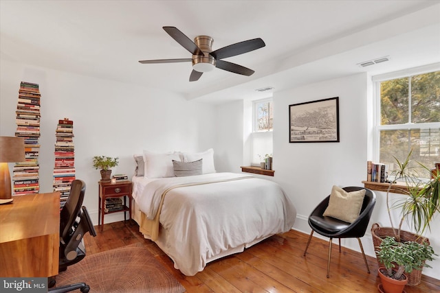 bedroom featuring ceiling fan, visible vents, and hardwood / wood-style floors