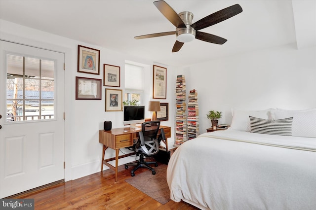 bedroom with ceiling fan, wood finished floors, and baseboards