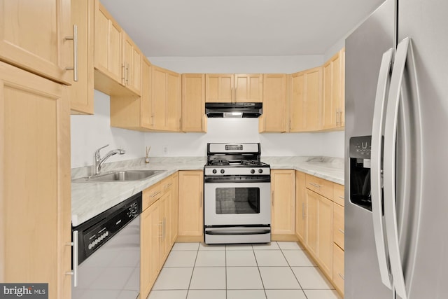 kitchen featuring stainless steel appliances, light brown cabinets, and a sink