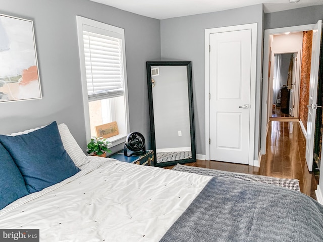 bedroom featuring wood finished floors and baseboards