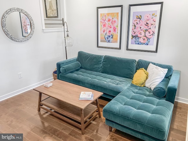 living area with baseboards and wood finished floors