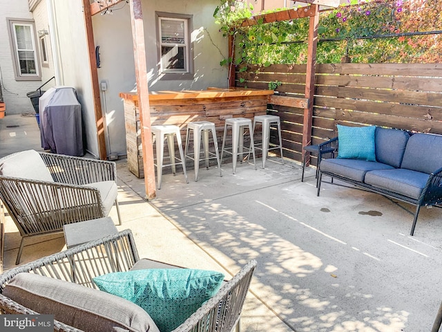 view of patio / terrace with outdoor dry bar, outdoor lounge area, and fence