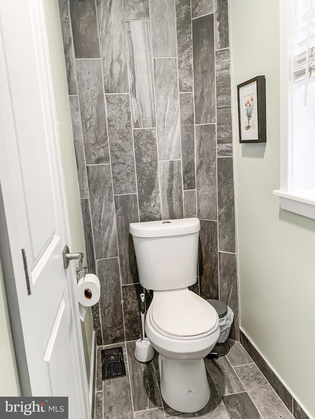 bathroom with visible vents, baseboards, and toilet