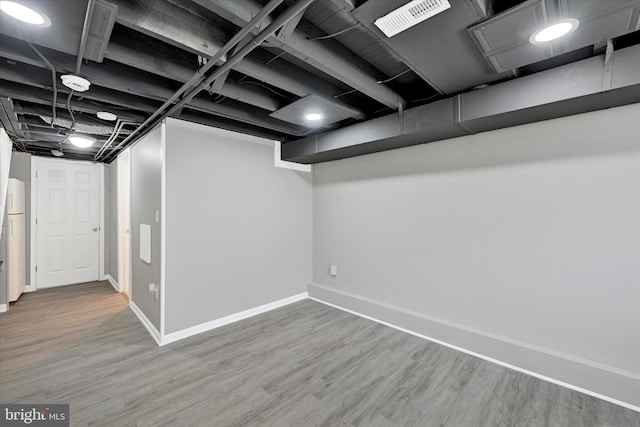 finished below grade area featuring visible vents, baseboards, and wood finished floors