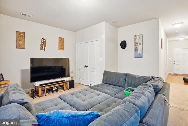 living area with visible vents, light carpet, and baseboards