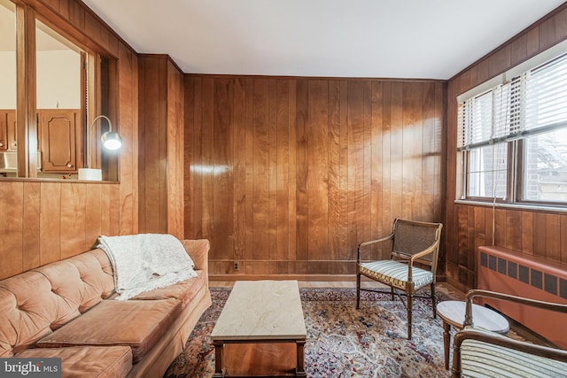 living area featuring radiator and wooden walls