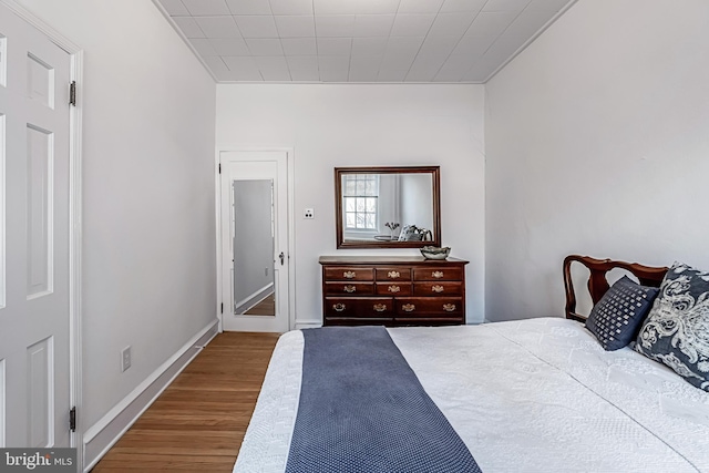 bedroom featuring baseboards and wood finished floors