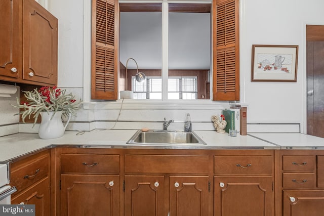 kitchen with brown cabinets, a sink, and light countertops