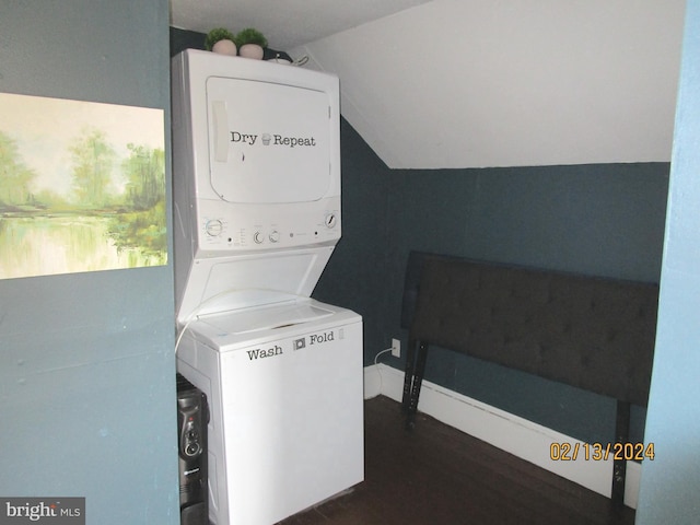 washroom with dark wood-style floors, stacked washer / dryer, and laundry area