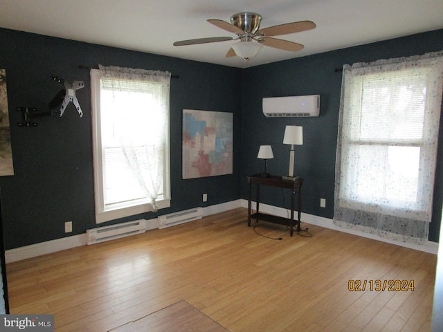 unfurnished room featuring a baseboard radiator, baseboards, hardwood / wood-style floors, and an AC wall unit