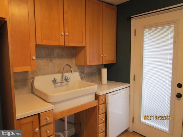 kitchen with a sink, decorative backsplash, dishwasher, and light countertops