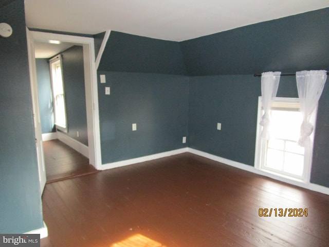 empty room with plenty of natural light, dark wood finished floors, and baseboards