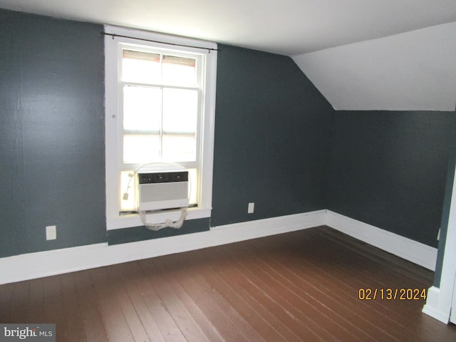 additional living space with cooling unit, baseboards, vaulted ceiling, and hardwood / wood-style floors