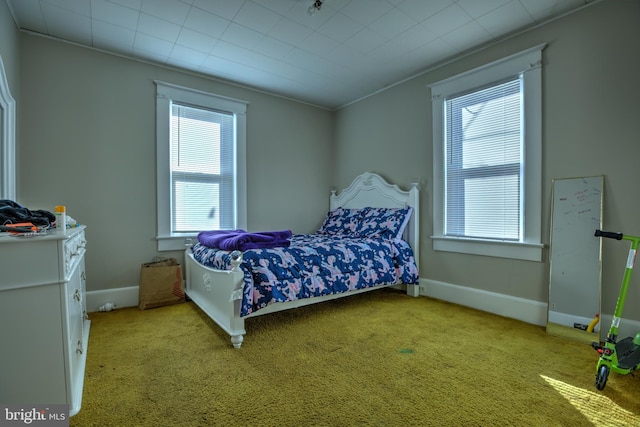 bedroom with baseboards and light colored carpet