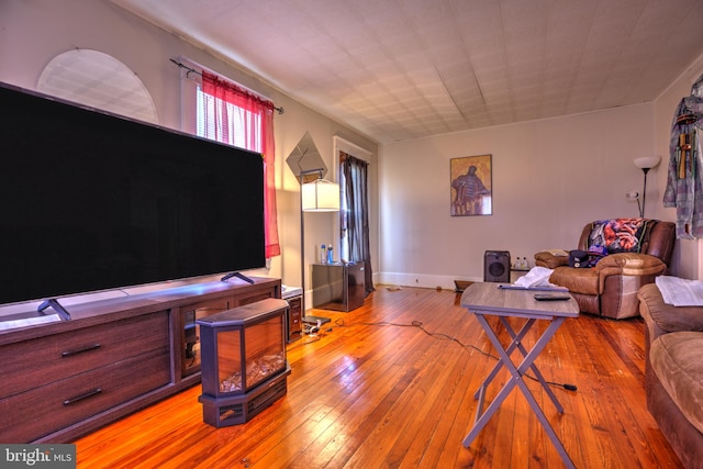 living area with hardwood / wood-style flooring and baseboards